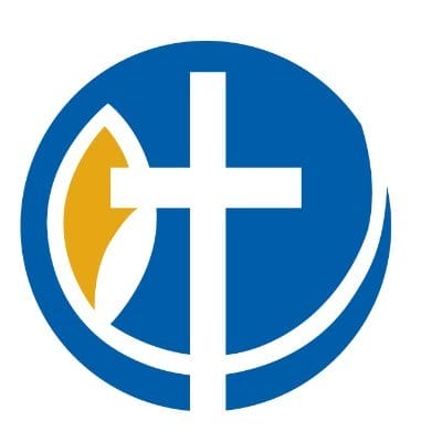A blue circle with a white Christian cross in the center, a gold and white leaf shape on the left, and a white curved line on the lower right, forming a stylized religious symbol. South Florida Business & Wealth