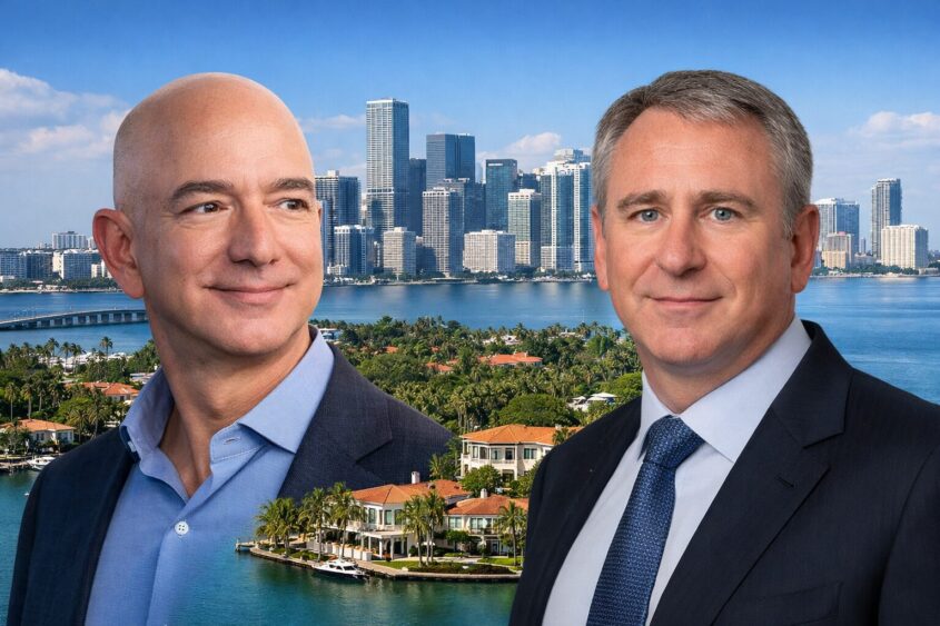 Two men in business suits stand in front of a backdrop featuring a city skyline with tall buildings, water, and luxury waterfront homes surrounded by palm trees, under a clear blue sky. South Florida Business & Wealth