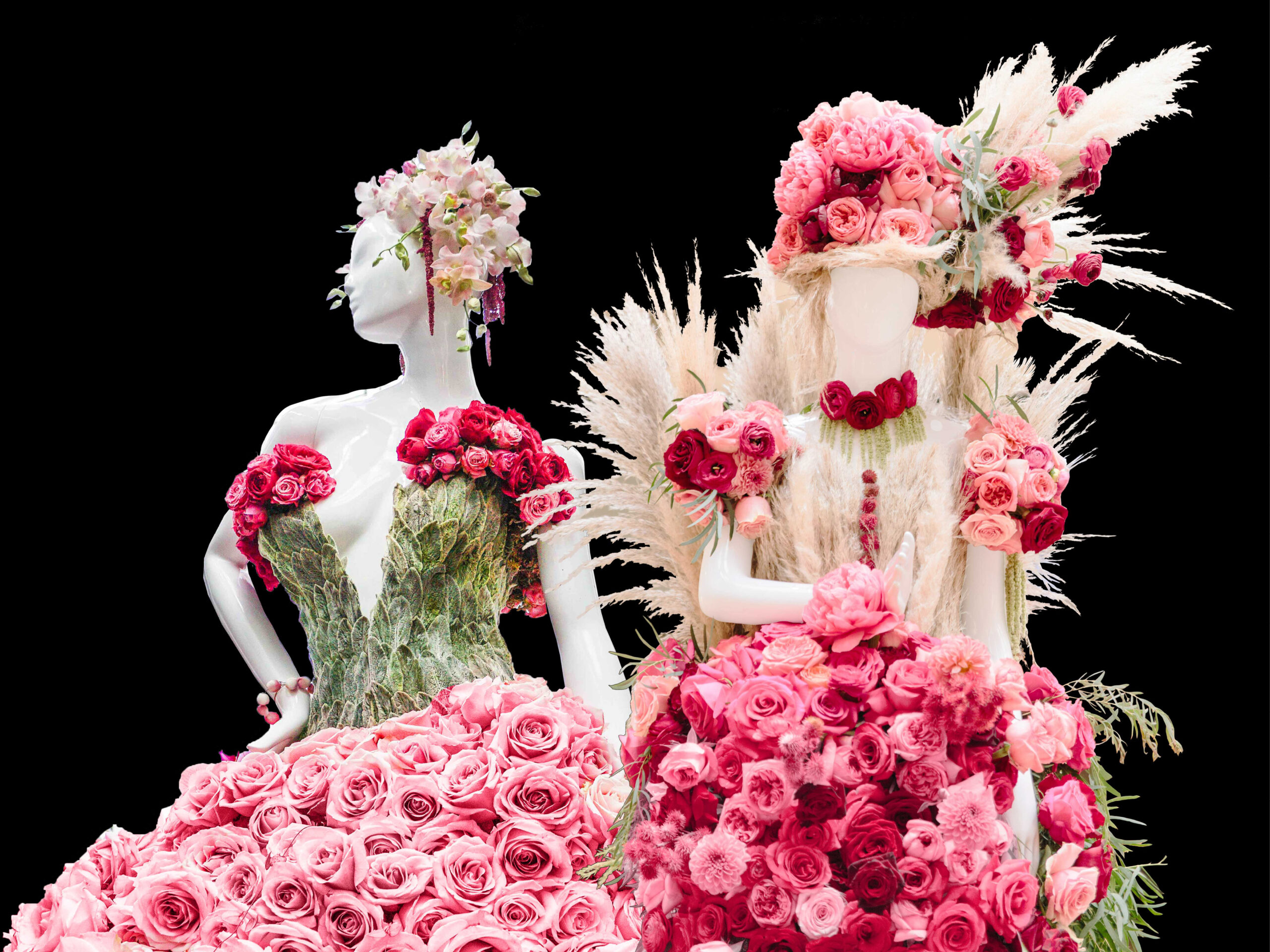 Two mannequins in elaborate dresses made of pink roses, greenery, and pampas grass stand against a black background. One wears a crown and gown of roses; the other is adorned with pampas grass and a floral bouquet. South Florida Business & Wealth