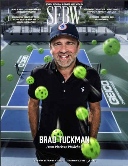 A man in a black polo shirt and cap stands smiling on a pickleball court with multiple pickleballs in motion around him. The magazine cover headline reads, "BRAD TUCKMAN: From Pixels to Pickleball. South Florida Business & Wealth