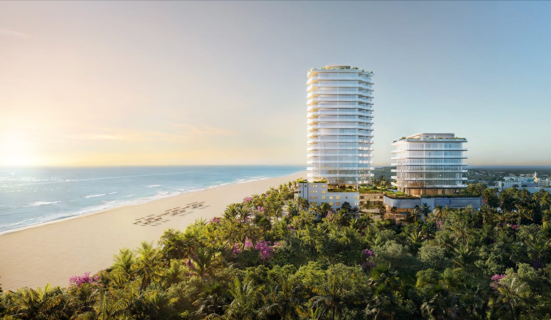 Two modern, glass high-rise buildings stand near a sandy beach lined with palm trees, with the ocean stretching out to the horizon under a clear sky at sunrise or sunset. South Florida Business & Wealth