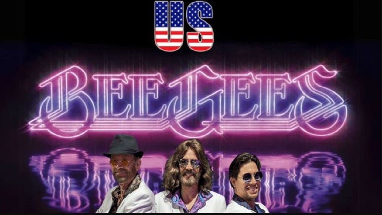 Three men in white suits and sunglasses stand in front of a neon sign that reads "Bee Gees," with a logo above them featuring the letters "US" filled with the American flag pattern. South Florida Business & Wealth