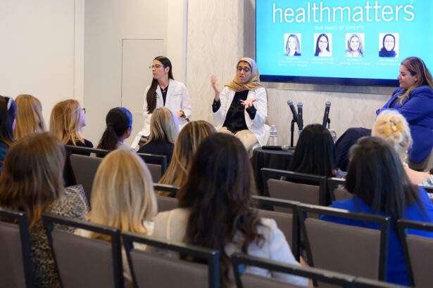 A diverse panel of three women, including two in medical coats, speaks to an audience at a "healthmatters" event. Audience members listen attentively as the panelists discuss health topics. South Florida Business & Wealth