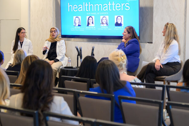 Four women sit at the front of a room, engaged in a panel discussion titled “healthmatters,” as an audience listens. Two microphones are on a table and panelists are dressed in business or medical attire. South Florida Business & Wealth