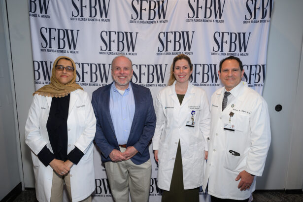 Four people stand in front of a backdrop with "SFBW South Florida Business & Wealth" repeated; two women and two men, with the men and one woman in white coats, and one man in a blue shirt and blazer. South Florida Business & Wealth