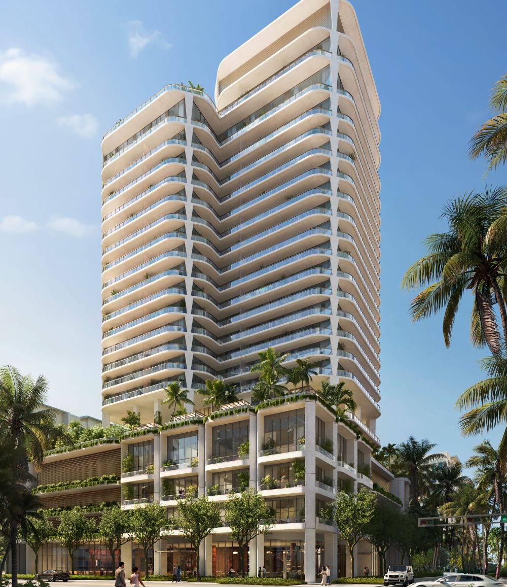 A modern high-rise building with curved balconies, lush greenery on the terraces, and a lower section featuring shops and trees, set against a clear blue sky with palm trees lining the street. South Florida Business & Wealth