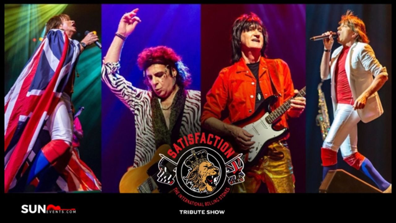 Four musicians in colorful costumes perform on stage with instruments, representing a Rolling Stones tribute band. The “Satisfaction” tribute show logo with a lion is centered at the bottom. Bright stage lights illuminate the scene. South Florida Business & Wealth