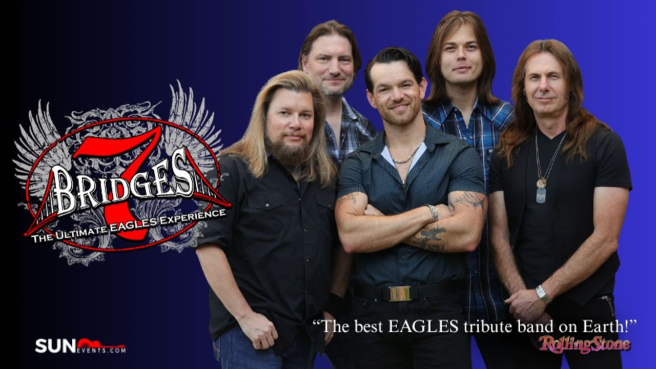Five men stand together in front of a blue background with a “7 Bridges: The Ultimate Eagles Experience” logo, and text calling them “The best EAGLES tribute band on Earth!”. South Florida Business & Wealth