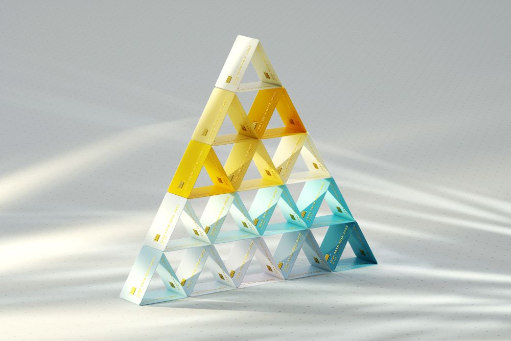 A pyramid-shaped structure made of triangular, translucent prisms in yellow, white, and blue, arranged in a gradient on a light, softly shadowed surface. South Florida Business & Wealth